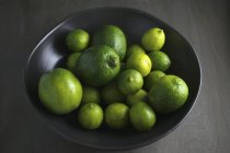Limes in black bowl — Stock Photo