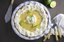 Key lime pie  on white plate over balck wooden surface — Stock Photo