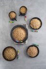 Vários tipos de grãos em copos e tigelas — Fotografia de Stock