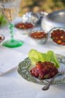 Томатна спеція з листям салату на тарілці над столом — стокове фото