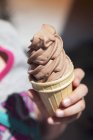 Chica sosteniendo un helado de chocolate - foto de stock