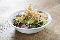 Salad with guacamole and fried tortilla strips — Stock Photo