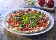 Pizza con tomates frescos y rúcula - foto de stock