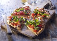 Pan de pizza con tomates y cohete - foto de stock