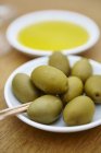 Green olives with wooden sticks — Stock Photo