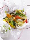 Colourful vegetables with herbs in parchment paper — Stock Photo