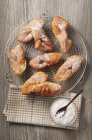 Vista superior de dulces de masa frita con azúcar en polvo en el estante de enfriamiento de alambre - foto de stock