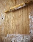 Top view of a floured wooden surface and a rolling pin — Stock Photo