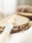 Rebanadas de pan y cuchillo con mantequilla - foto de stock