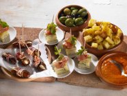 Elevated view of assorted tapas with meat and olives — Stock Photo