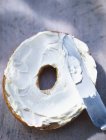 Half bagel spread with cream — Stock Photo