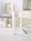 Nahaufnahme von gekühltem Wasserglas auf weißer Oberfläche — Stockfoto