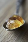 Nahaufnahme von braunem Steinzucker auf einem Silberlöffel — Stockfoto