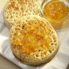 Closeup view of Crumpets with marmalade on white dish — Stock Photo