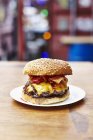 Cheeseburger duplo com bacon na placa — Fotografia de Stock