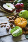 Eine Anordnung von Obst, Gemüse und Nüssen auf einer Holzoberfläche — Stockfoto