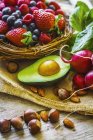 Ein Arrangement aus Beeren, Gemüse und Nüssen auf einer Holzoberfläche — Stockfoto