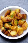Roasted potatoes in enamel bowl — Stock Photo