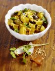 Eingelegte, Curry-Zucchini in weißer Schüssel über Holzoberfläche — Stockfoto