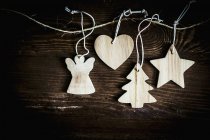 Vista superior de decoraciones navideñas de madera en cuerdas - foto de stock