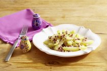 Kohlrabi medley with ham  on white plate over  wooden surface  with fork — Stock Photo