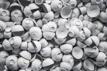 Vista dall'alto di tazze di porcellana bianca, ciotole zuppa e cucchiai mucchio — Foto stock
