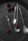 Vecchi cucchiai d'argento e ciliegie — Foto stock