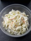 Coleslaw in take-away container in glass bowl — Stock Photo