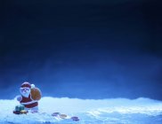 Vista de primer plano de Papá Noel con dulces contra una superficie azul - foto de stock