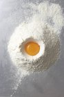 Egg yolk in heap of flour — Stock Photo
