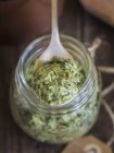 Vista close-up de ervas vegan Pesto em uma colher e em um frasco — Fotografia de Stock