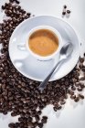 Taza de café expreso en granos de café - foto de stock