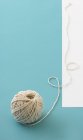 Closeup view of a ball of twine on a light-blue surface — Stock Photo