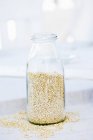 Quinoa in glass bottle — Stock Photo