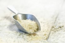 Weißer ungekochter Reis auf Metalllöffel — Stockfoto