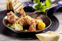 Closeup view of prawns wrapped in bacon with herbs — Stock Photo