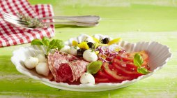 Томатний салат з моцарелою та салямі — стокове фото