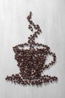 Grãos de café dispostos em forma de xícara — Fotografia de Stock