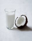 Une demi-noix de coco et du verre — Photo de stock