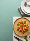 Orange and grapefruit pie with lemon balm over green surface — Stock Photo