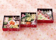 Повышенный вид японских коробок для ланча с различными рулонами — стоковое фото