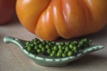 Green peppercorns and tomato — Stock Photo