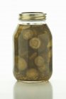Homemade pickles in a screw-top jar on white surface — Stock Photo