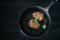 Pepper steaks in black cast-iron pan — Stock Photo