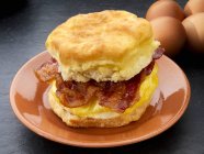Closeup view of American biscuit with bacon and scrambled egg — Stock Photo