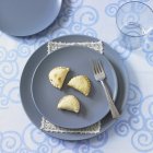 Top view of place setting with blue plates and mushroom filled pastry parcels — Stock Photo