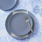 Top view of a place setting with blue plates and a fork — Stock Photo