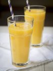Smothie aux fruits tropiques jaunes en deux grands verres
. — Photo de stock
