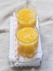 Vue rapprochée de smothie fruits tropiques jaunes en deux verres — Photo de stock