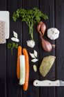Un arrangement de légumes-soupe et de persil sur une surface en bois sombre — Photo de stock